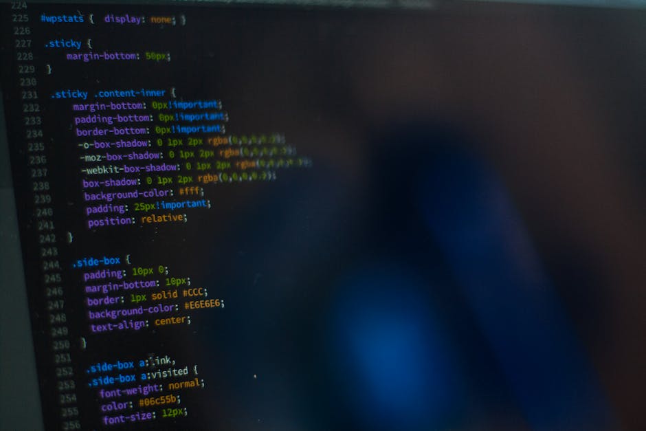 Close-up view of a computer screen displaying lines of code with various syntax highlighting in different colours, including yellow, green, purple, and blue. The code appears to be related to CSS styl